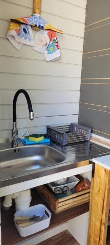 a kitchen counter with a sink and a sink at Glamping Bosque - Río Villarrica in Villarrica