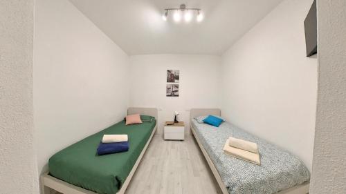 two beds in a room with white walls at Il Gatto e La Volpe Foresteria Lombarda in Lierna