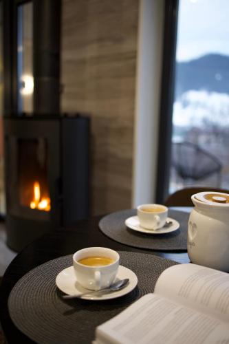 two cups of coffee on a table with a fireplace at Petrick House in Verkhovyna