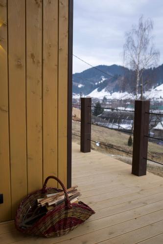 a wicker basket sitting on a wooden deck with a window at Petrick House in Verkhovyna