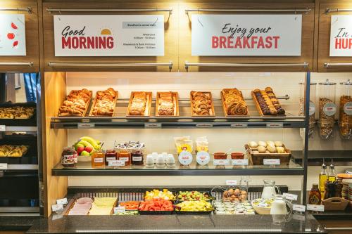 uma padaria cheia de diferentes tipos de alimentos em Point A Hotel Edinburgh Haymarket em Edinburgo