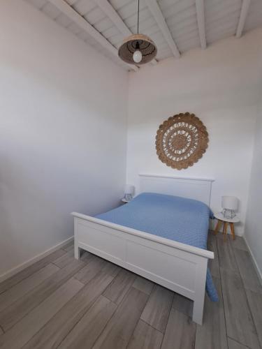 a bedroom with a bed with blue sheets and a ceiling at Casa Azul do Cerro in Campeiros