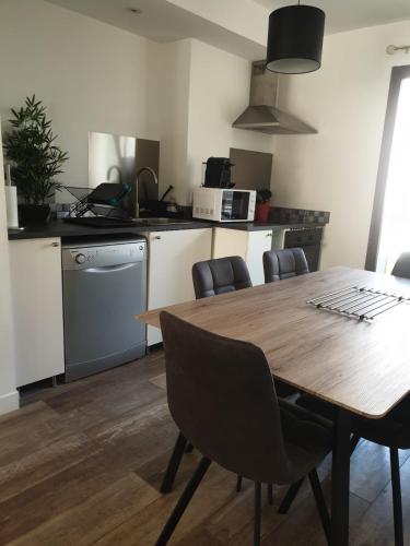 Il comprend une cuisine avec une table et des chaises en bois. dans l'établissement Hyères - Centre Ville - Private parking, à Hyères