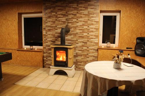 a fireplace in a room with a table and a stove at Mažasis SPA in Merkinė