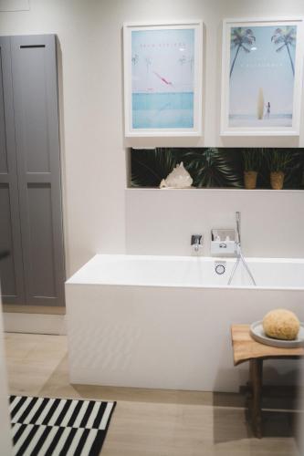 a white bathroom with a tub and a table at Designer loft with terrace in Neuss
