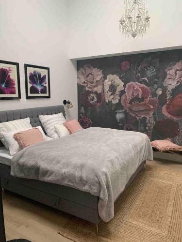 a bedroom with a large bed with a floral wallpaper at Designer loft with terrace in Neuss