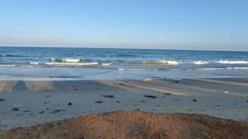 a sandy beach with waves in the ocean at Gunam guest house in Point Pedro