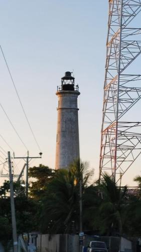 a lighthouse on a hill with a electricity tower at Gunam guest house in Point Pedro