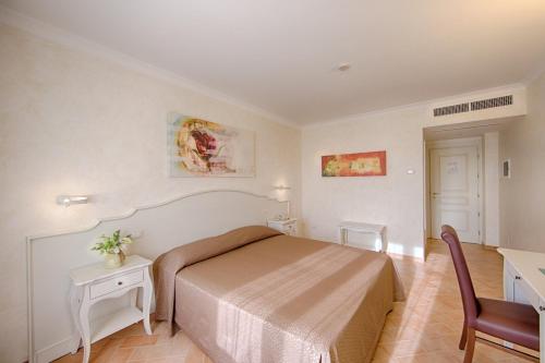 a bedroom with a bed and a desk and a chair at Relais Masseria Caselli in Carovigno