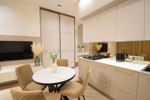 a kitchen with a table and chairs in a kitchen at Vilniaus 99 Apartamentai in Šiauliai