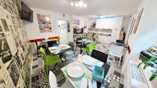 a dining room with a table and green chairs at Il Gatto e La Volpe Foresteria Lombarda in Lierna