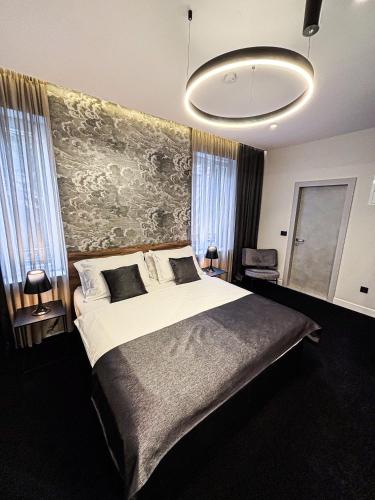a bedroom with a large bed and a painting on the wall at Calma Luxury Rooms in Split