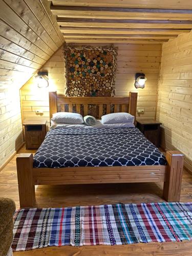 ein Schlafzimmer mit einem Bett in einem Holzzimmer in der Unterkunft Номер 6 Садиба У Ані in Synewyrska Poljana