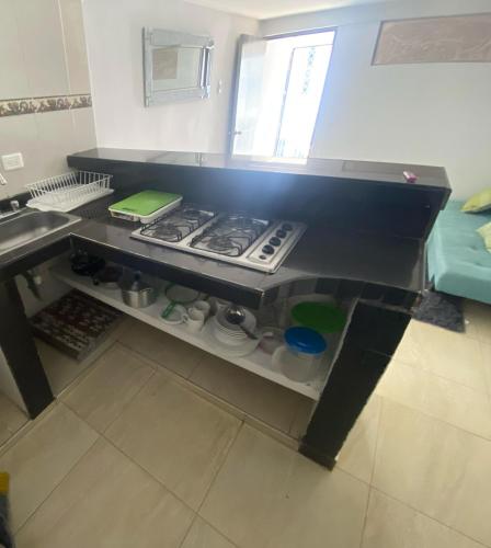 a kitchen with a counter top with a stove at El Encanto II - ApartaSuites in Barranquilla