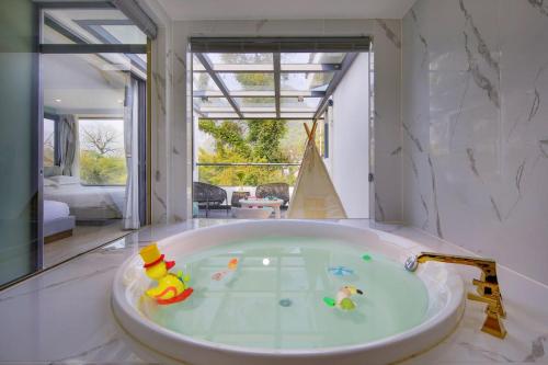 Hotel Del Moon في يانغتشو: حمام كبير مع حوض به ألعاب