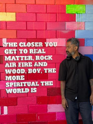 a man standing in front of a brick wall at beNomadic Eco Hostel, Madikeri, Coorg in Suntikoppa
