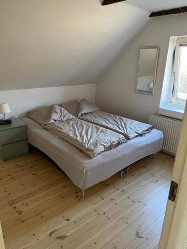 a bed in a room with a wooden floor at Holiday Home Penthouse Lemvig in Lemvig