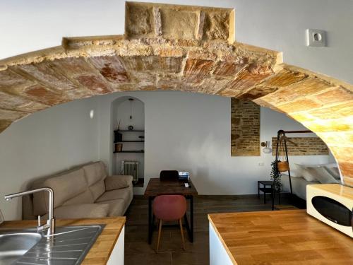 a kitchen and living room with a couch and a table at CasaElbarranko in Arcos de la Frontera