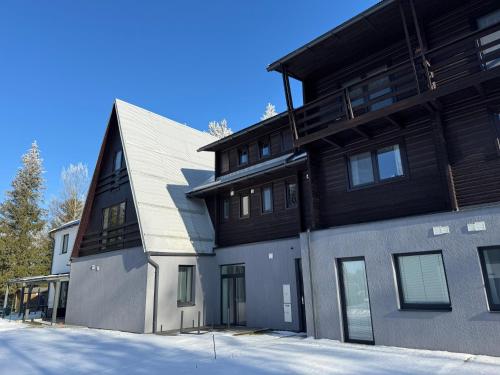 a black and gray house with a lot of windows at Apartmán na Vysočině in Svratouch