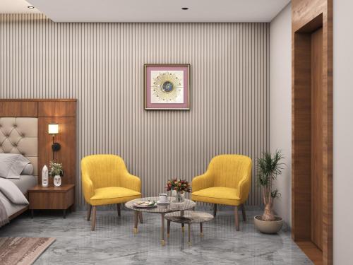 a living room with two yellow chairs and a table at Prince Palace And Banquet in Pāndharkawada