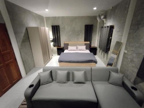 a bedroom with a bed and a couch in it at Loft House 3 Bedrooms in Pai