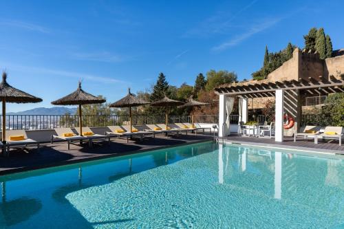 una piscina en un hotel con sillas y sombrillas en Parador de Málaga Gibralfaro, en Málaga