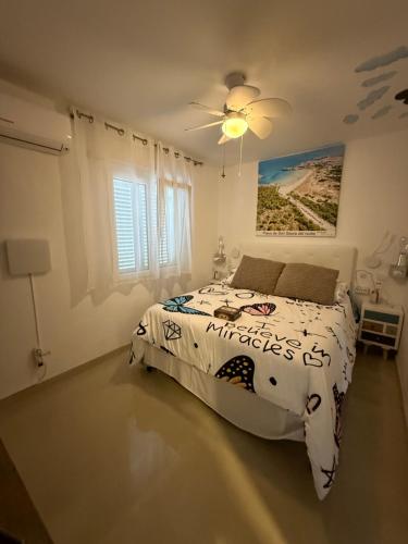 a bedroom with a bed and a ceiling fan at FLAT Surrounded by Nature WIFI & Pool & beach Nearby in Son Parc