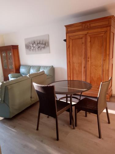 un salon avec une table, des chaises et un canapé dans l'établissement Charmante Chambre 