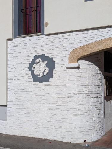 a brick wall with a sign on the side of a building at Casa Tartaruga in SantʼAntìoco