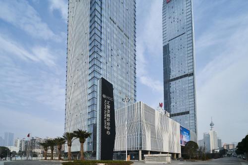 two tall skyscrapers in a city with buildings at Ziggy Hotel in Changsha