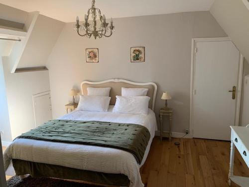 a bedroom with a large bed and a chandelier at Loft Montaigne Cité médiévale Sarlat in Sarlat-la-Canéda