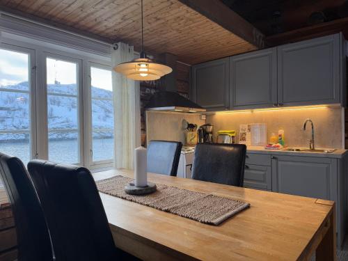 a kitchen with a wooden table with a candle on it at Sakrisøy Rorbuer in Reine