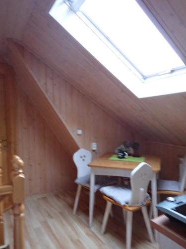 a room with a table and chairs and a skylight at Natura Bukowina Tatrzańska in Bukowina Tatrzańska