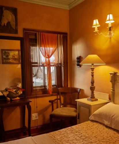 a bedroom with a bed and a chair and a window at TwoAngels in Knysna