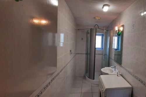 a bathroom with a sink and a shower and a toilet at Maison de pêcheur in Brem-Sur-Mer