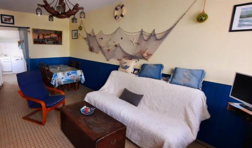 a living room with a couch and a table at Maison de pêcheur in Brem-Sur-Mer
