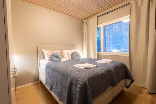 a bedroom with a bed with two towels on it at Kaisantien Kirsti, Vuokatti in Vuokatti
