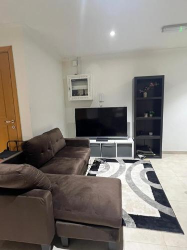 a living room with a couch and a flat screen tv at Tabs Dubai Hostel in Dubai