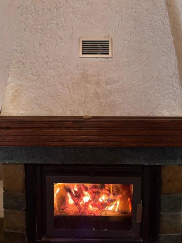 a fireplace with an air vent above it at To XYLINO in Áno Potamiá