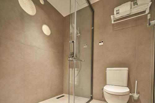 a bathroom with a toilet and a glass shower at Ziggy Hotel in Changsha