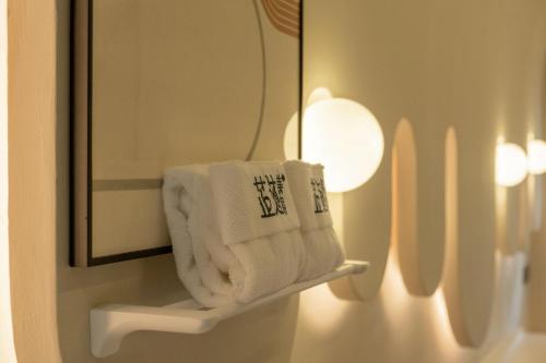a towel on a shelf in a bathroom with a mirror at Ziggy Hotel in Changsha