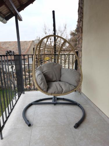 a rattan chair sitting on a balcony at Hanna Vendégház-Tállya in Tállya