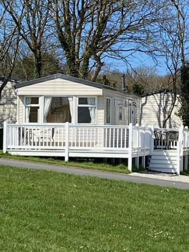 a white house with a porch and a white fence at Cosy 2 bed pet friendly holiday home Crantock Nr Newquay in Crantock