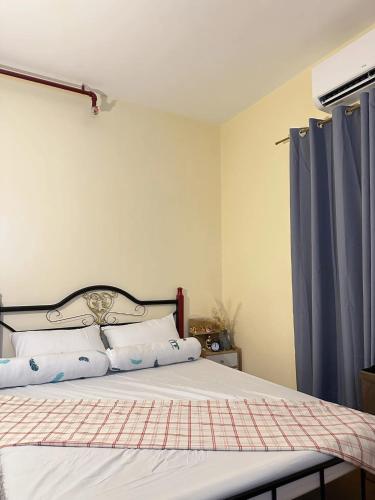 a bedroom with a bed with blue curtains at Classy Condo in CDO in Cagayan de Oro