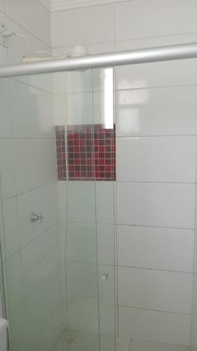 a shower with a glass door with a red tile at Melhor custo benefício in Belém