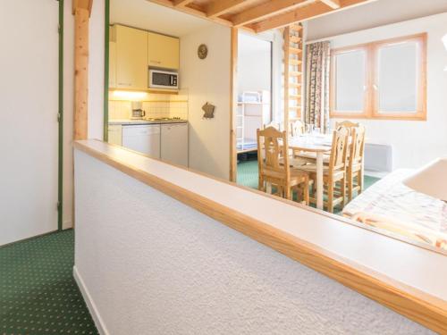 une cuisine et une salle à manger avec une table dans l'établissement Appartement spacieux près des pistes avec balcon - FR-1-181-2495, à La Plagne Tarentaise
