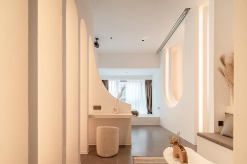 a living room with white walls and a window at Ziggy Hotel in Changsha