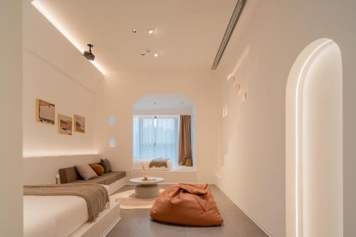 a bedroom with a bed and a couch and a window at Ziggy Hotel in Changsha