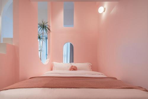 a bedroom with a large bed with pink walls at Ziggy Hotel in Changsha