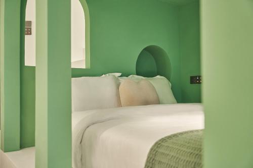 a bedroom with green walls and a bed with pillows at Ziggy Hotel in Changsha